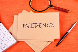 Evidence file to support a GP surgery data breach claim on an orange background with a pen and magnifying glass. 